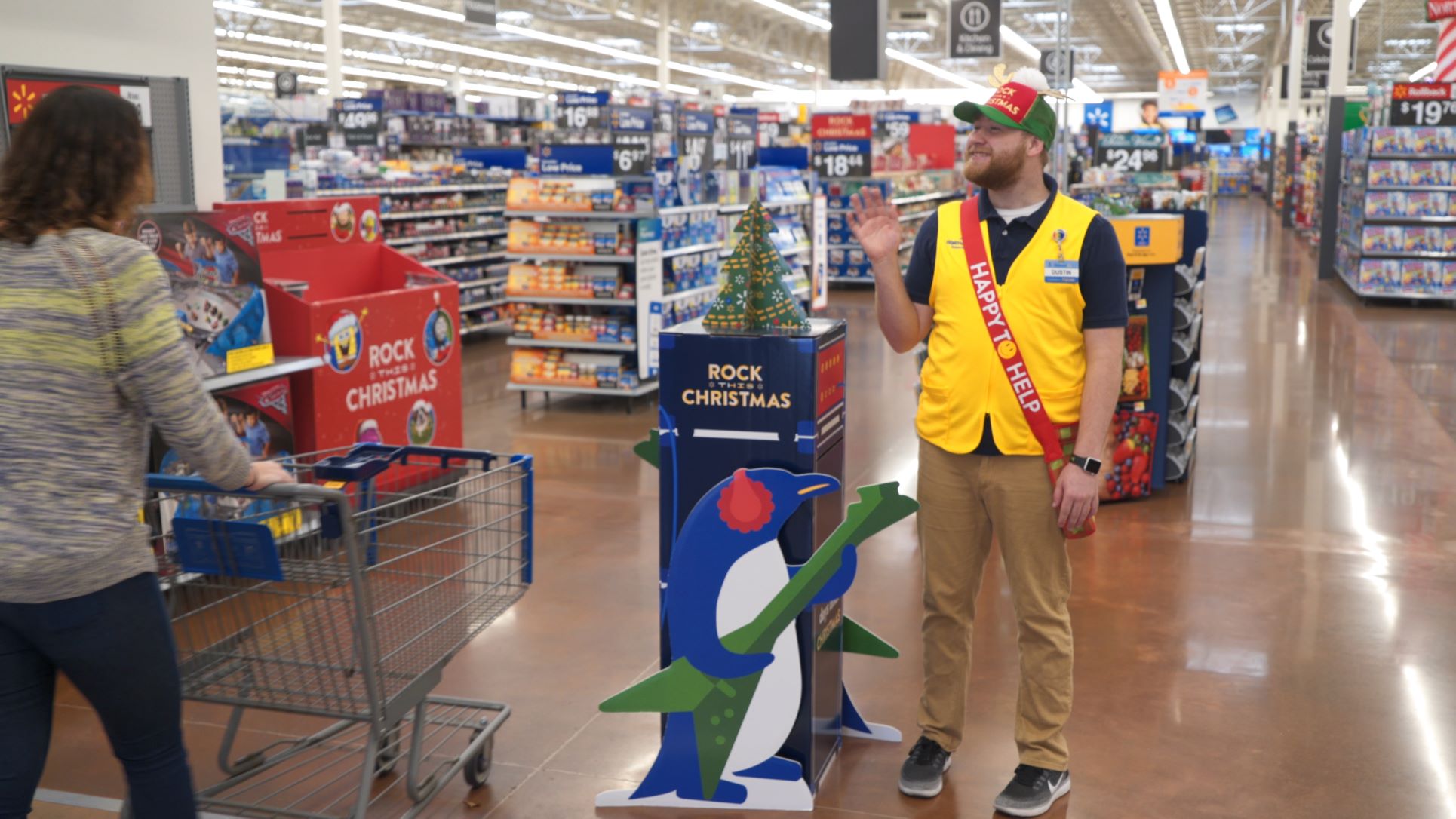Walmart employee greets shopper to the store's full inventory shelves