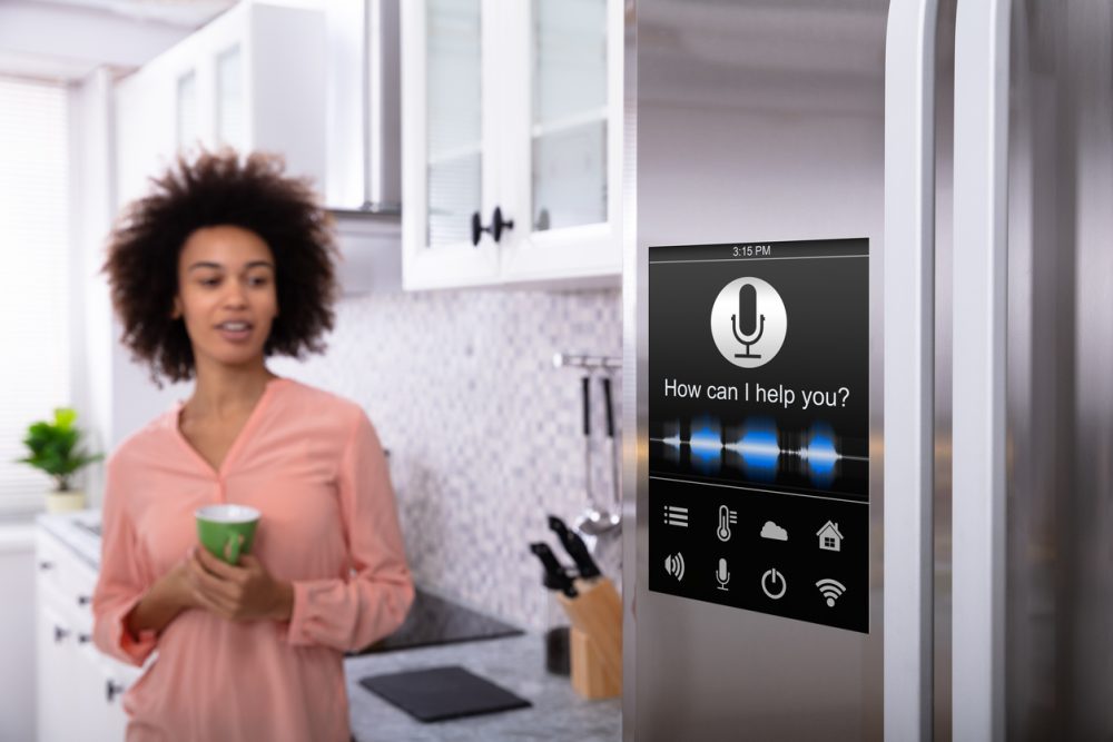 A person using speech commands with the smart fridge in their kitchen