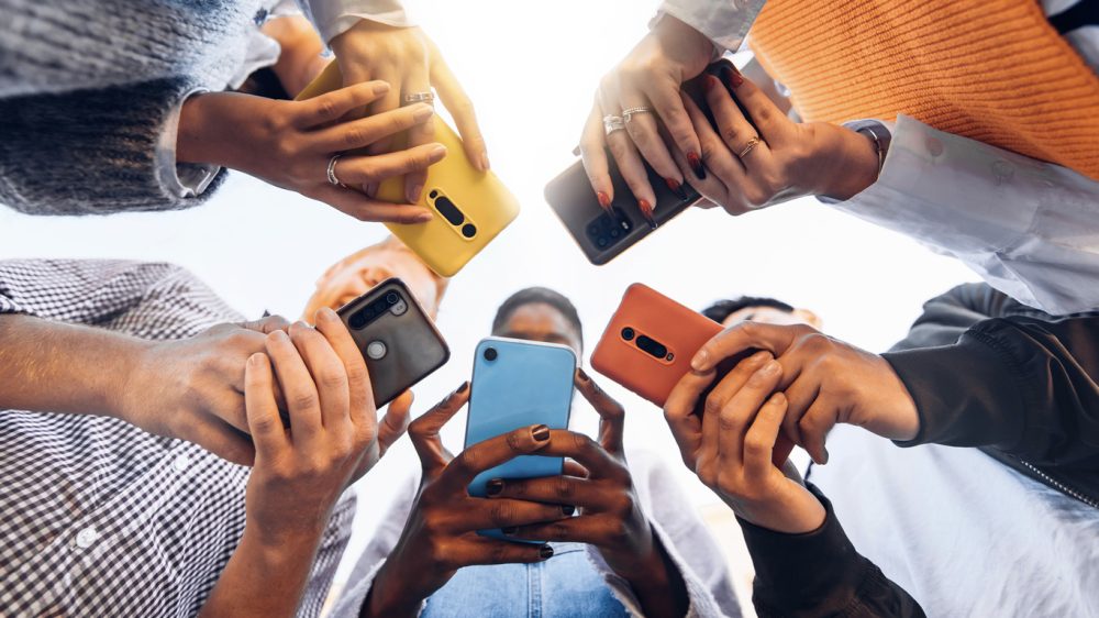 Teens in circle holding smart phones